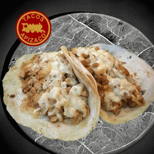 Dos tortillas de harina con bistec picado y queso fundido sobre un plato de mármol.